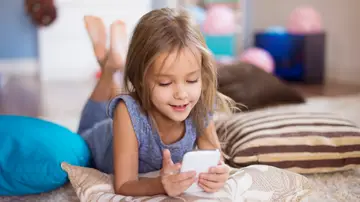 Niña con un móvil en la mano Niña con un móvil en la mano