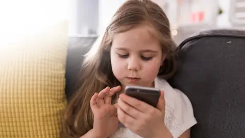 Niña con un móvil en la mano Niña con un móvil en la mano