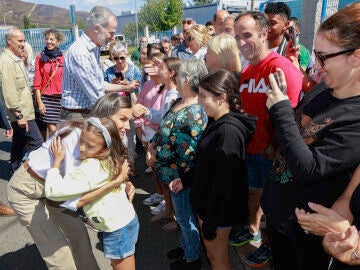 Los reyes Felipe VI y Letizia saludan a varios niños mientras visitan un colegio público de la parroquia de Medieros, en Monterrei (Ourense)