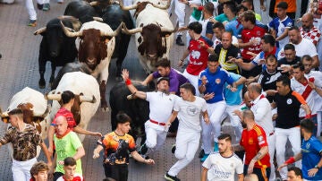 Los corredores son perseguidos por los toros durante el quinto encierro de San Sebastián de los Reyes este jueves.