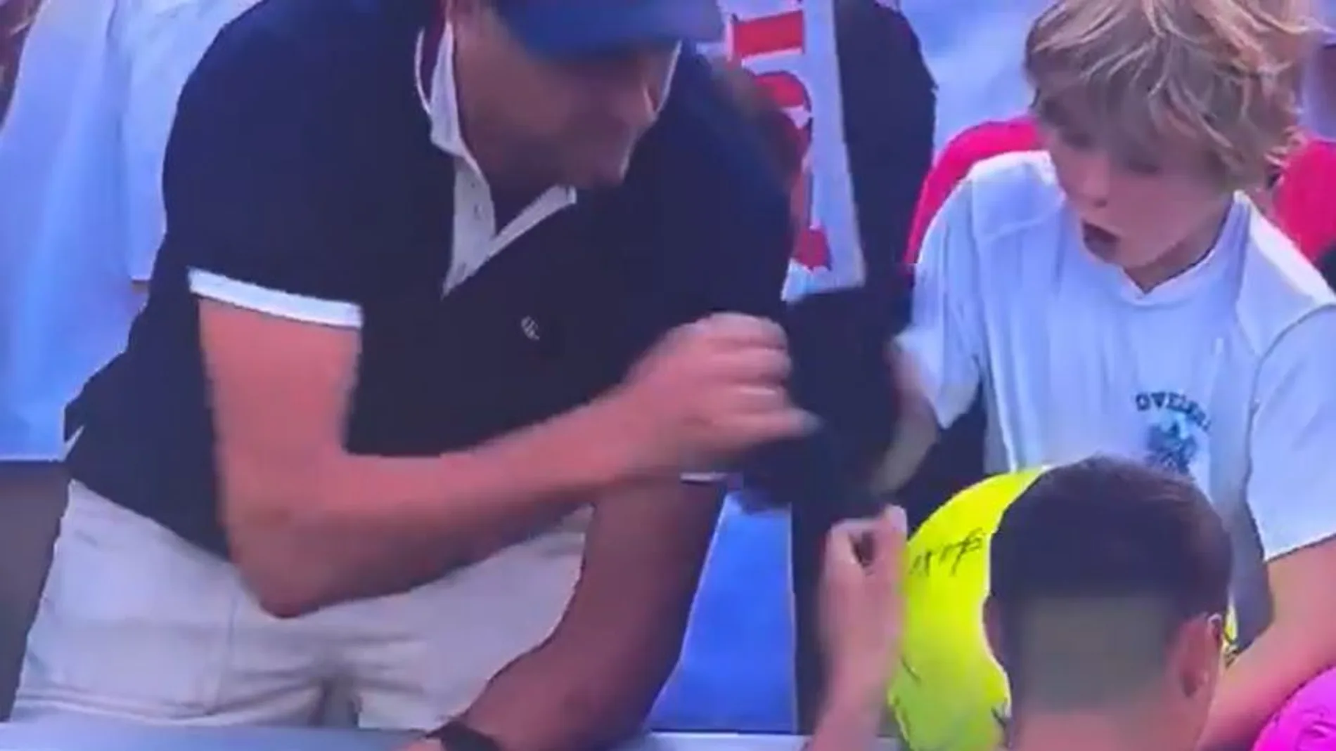 El hombre quitando la gorra a un niño tras un partido del US Open El hombre quitando la gorra a un niño tras un partido del US Open