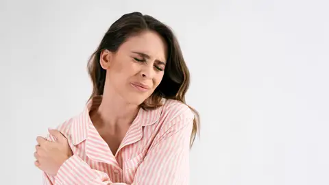 Mujer doliéndose del hombro Mujer doliéndose del hombro