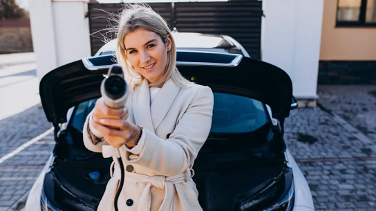 Mujer cargando un coche eléctrico Mujer cargando un coche eléctrico