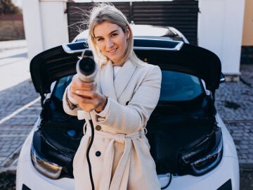 Mujer cargando un coche eléctrico Mujer cargando un coche eléctrico