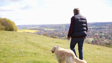 Un hombre paseando con un perro
