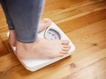Persona sobre una báscula Persona sobre una báscula