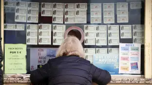 Una mujer comprando décimos de la lotería de Navidad Una mujer comprando décimos de la lotería de Navidad
