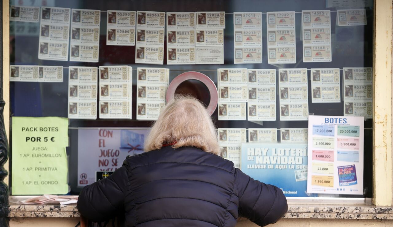 Una mujer comprando d&eacute;cimos de la loter&iacute;a de Navidad