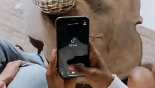 Una persona abriendo la aplicación de TikTok