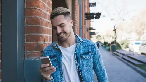 Chico joven con el teléfono en la mano Chico joven con el teléfono en la mano