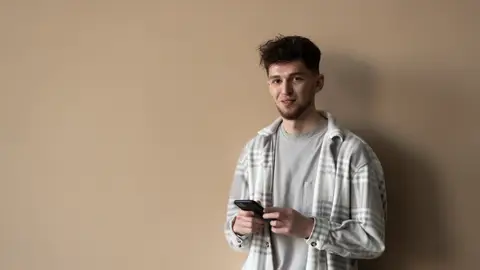 Chico joven con el teléfono en la mano Chico joven con el teléfono en la mano