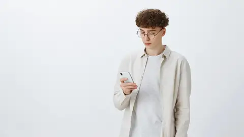 Chico joven con el teléfono en la mano Chico joven con el teléfono en la mano