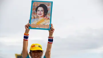 Fotografía de archivo de una mujer mientras sostiene una fotografía de la reina madre de Tailandia Fotografía de archivo de una mujer mientras sostiene una fotografía de la reina madre de Tailandia