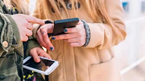 Imagen de archivo de dos personas con móviles Imagen de archivo de dos personas con móviles