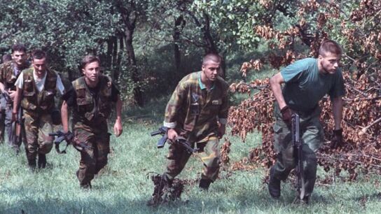 Soldados bosnios avanzan en una las colinas que rodean la ciudad sitiada de Sarajevo, 9 de agosto de 1992.