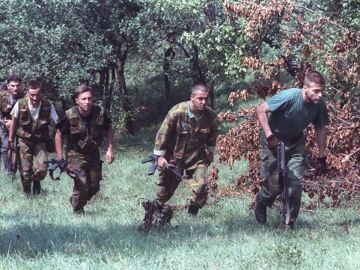 Soldados bosnios avanzan en una las colinas que rodean la ciudad sitiada de Sarajevo, 9 de agosto de 1992.