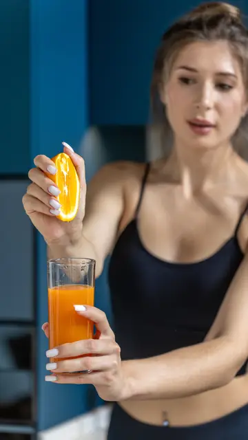 Mujer exprimiendo una naranja Mujer exprimiendo una naranja