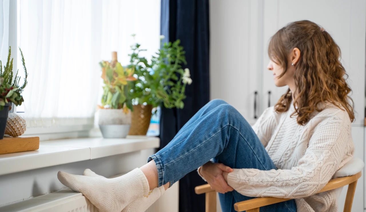 Mujer con los pies en el radiador
