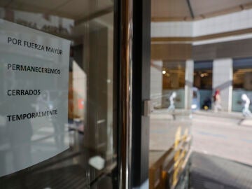 Cartel que indica el cierre temporal en la fachada principal de la clínica dental de Alzira (València)