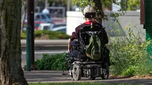 Una persona en silla de ruedas Una persona en silla de ruedas