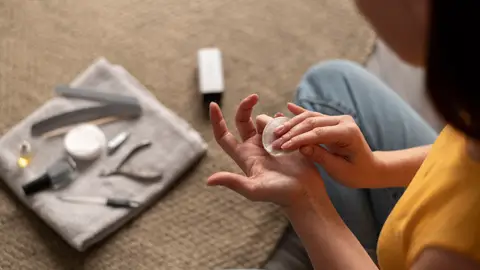 Mujer usando quitaesmaltes Mujer usando quitaesmaltes