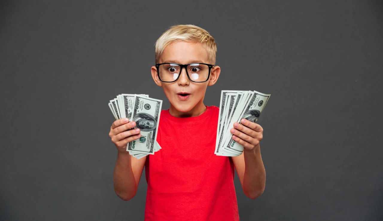 Un niño muy contento con dinero en las manos