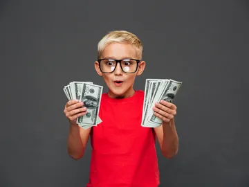 Un niño muy contento con dinero en las manos Un niño muy contento con dinero en las manos