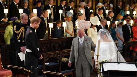 Carlos III acompañando a Meghan al altar, dónde la espera Harry