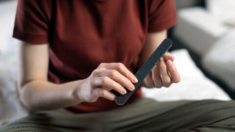 Persona limándose las uñas