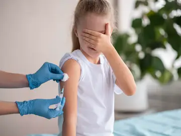 Una niña recibe una vacuna Una niña recibe una vacuna