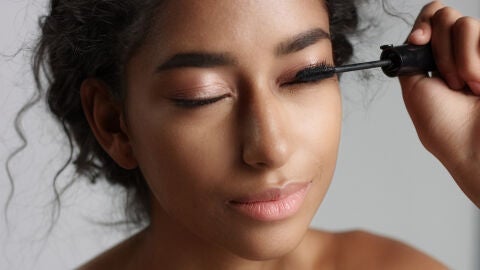 Mujer aplicándose máscara de pestañas