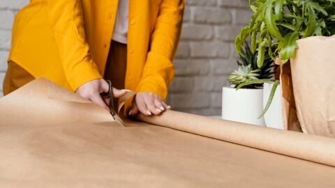 Mujer cortando papel kraft