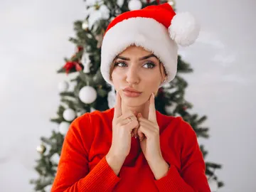 Una mujer en Navidad con cara de duda Una mujer en Navidad con cara de duda