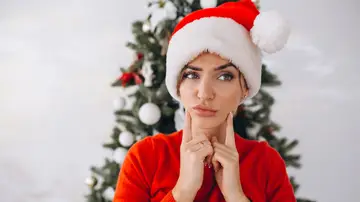 Una mujer en Navidad con cara de duda Una mujer en Navidad con cara de duda