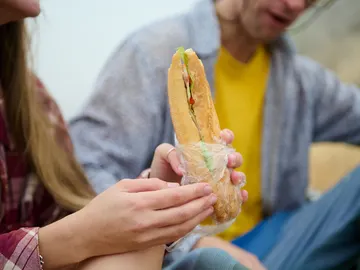 Una pareja se come un bocadillo en el campo Una pareja se come un bocadillo en el campo