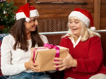 Hija dando un regalo de Navidad a su madre Hija dando un regalo de Navidad a su madre