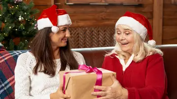 Hija dando un regalo de Navidad a su madre Hija dando un regalo de Navidad a su madre