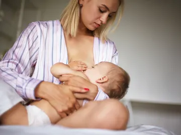 Una madre da el pecho a su bebé Una madre da el pecho a su bebé