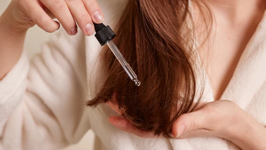 Chica echándose aceite en el pelo Chica echándose aceite en el pelo