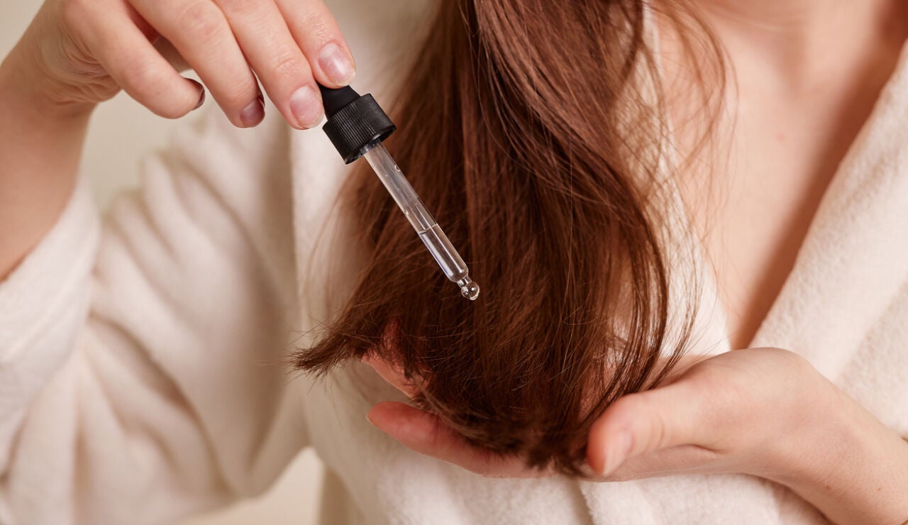 Chica ech&aacute;ndose aceite en el pelo