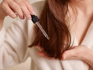 Chica echándose aceite en el pelo Chica echándose aceite en el pelo