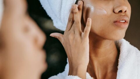 Mujer aplicándose cosméticos en el rostro