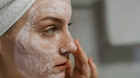 Mujer aplicándose cosméticos en el rostro Mujer aplicándose cosméticos en el rostro
