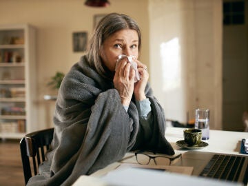 Una mujer resfriada con congesti&oacute;n nasal