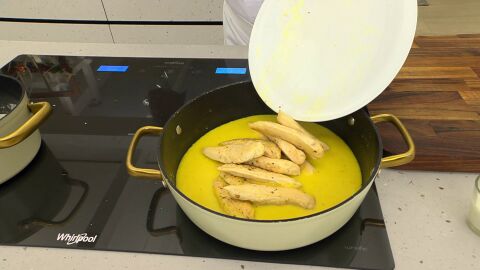 Pasa la salsa a una cazuela, vierte la nata, mezcla e incorpora los solomillos de pollo