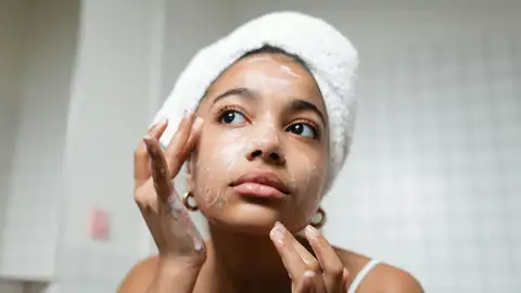 Mujer aplicándose cosméticos en el rostro Mujer aplicándose cosméticos en el rostro