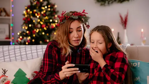 Madre e hijo mirando el móvil en Navidad Madre e hijo mirando el móvil en Navidad