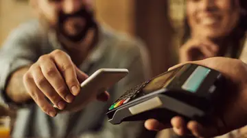 Una pareja paga con tarjeta Una pareja paga con tarjeta