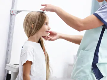 Pediatra midiendo la altura de una niña Pediatra midiendo la altura de una niña