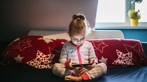 Niña con un móvil en Navidad Niña con un móvil en Navidad